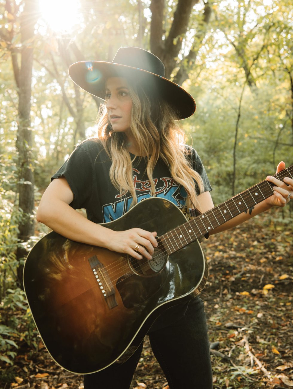 Caitlyn Smith with guitar in the woods